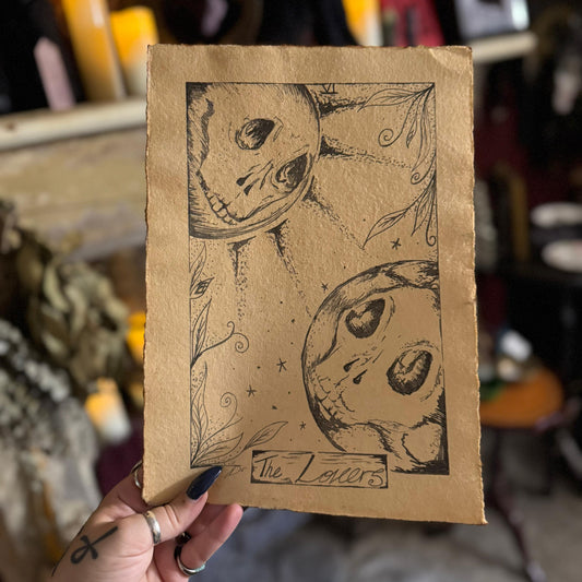 Hand holding a brown paper bag with black ink illustrations of pumpkins and text.