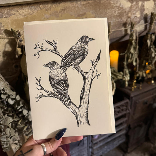 Card with black ink illustration of two birds on a branch held by a person.