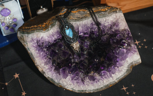 The Morrigan 
This beautiful Amulet is made with a gorgeous Labradorite crystal and a faux raven skull copper weaved with intention by the amazing Witchcrafted Rebecca.

A True statement Piece