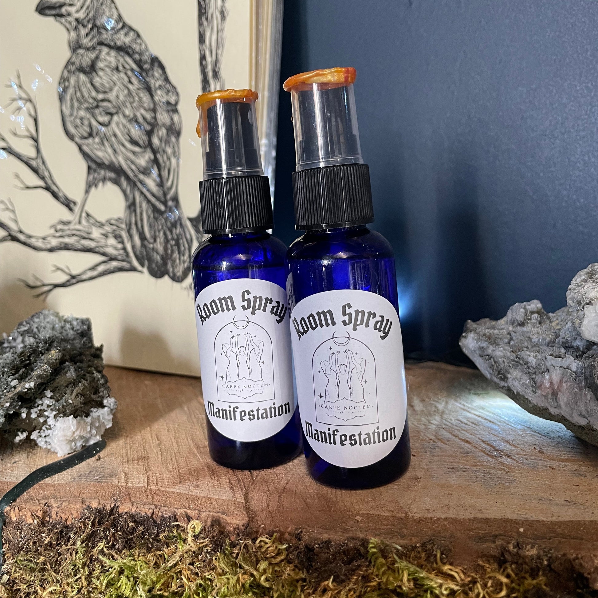 Two small blue bottles with white labels on a wooden surface with natural elements.