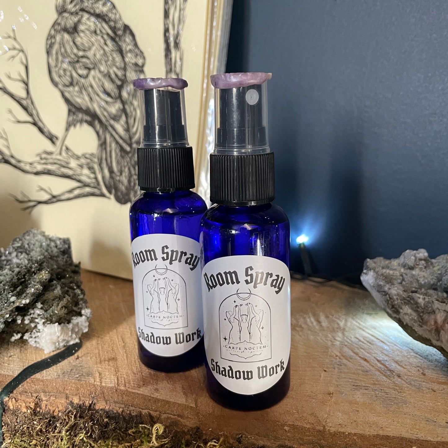 Two bottles of room spray on a wooden surface with a natural background